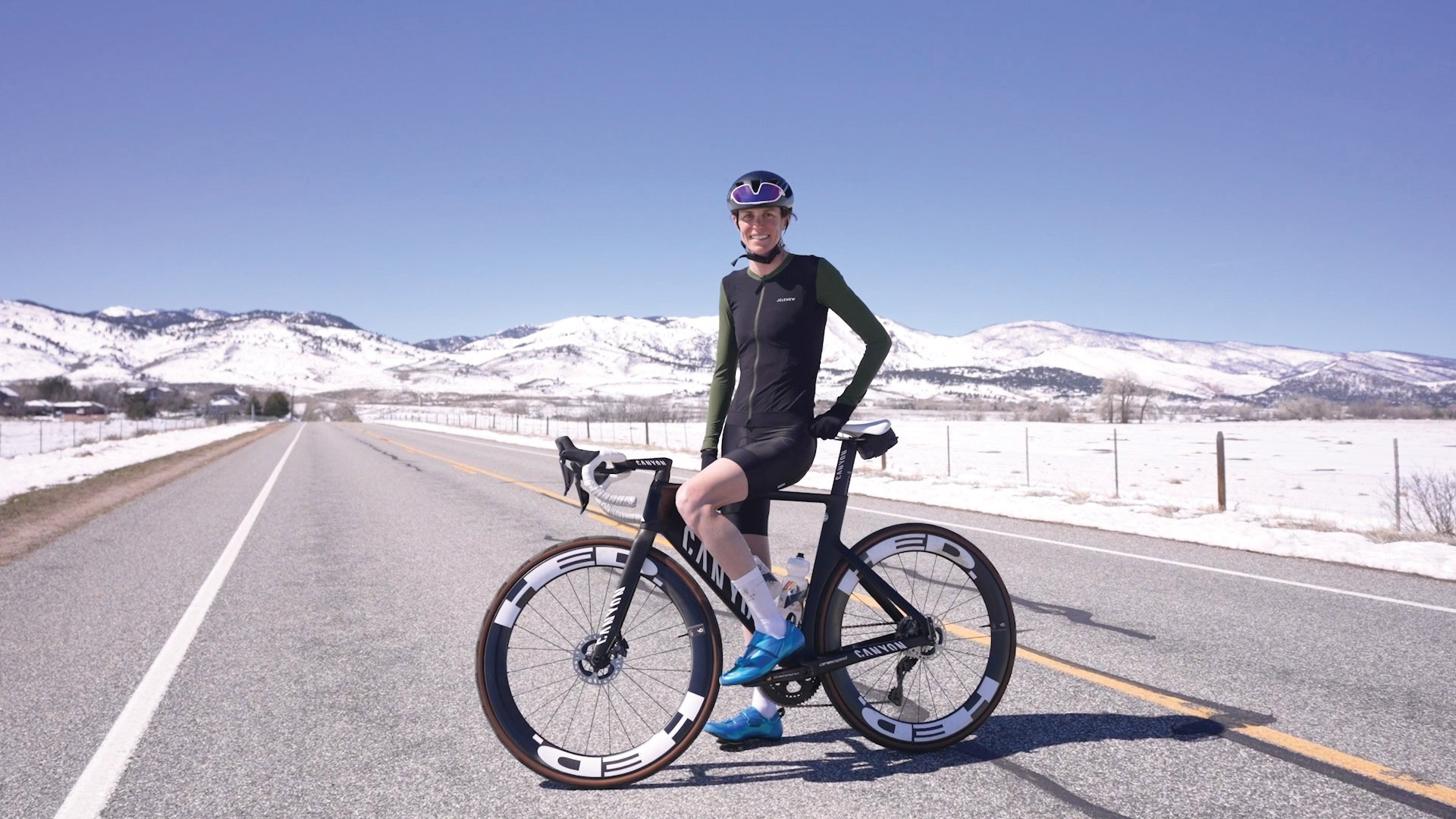 gwen jorgensen poses on her bike during an outdoor winter ride, sporting a dark jelenew bike kit