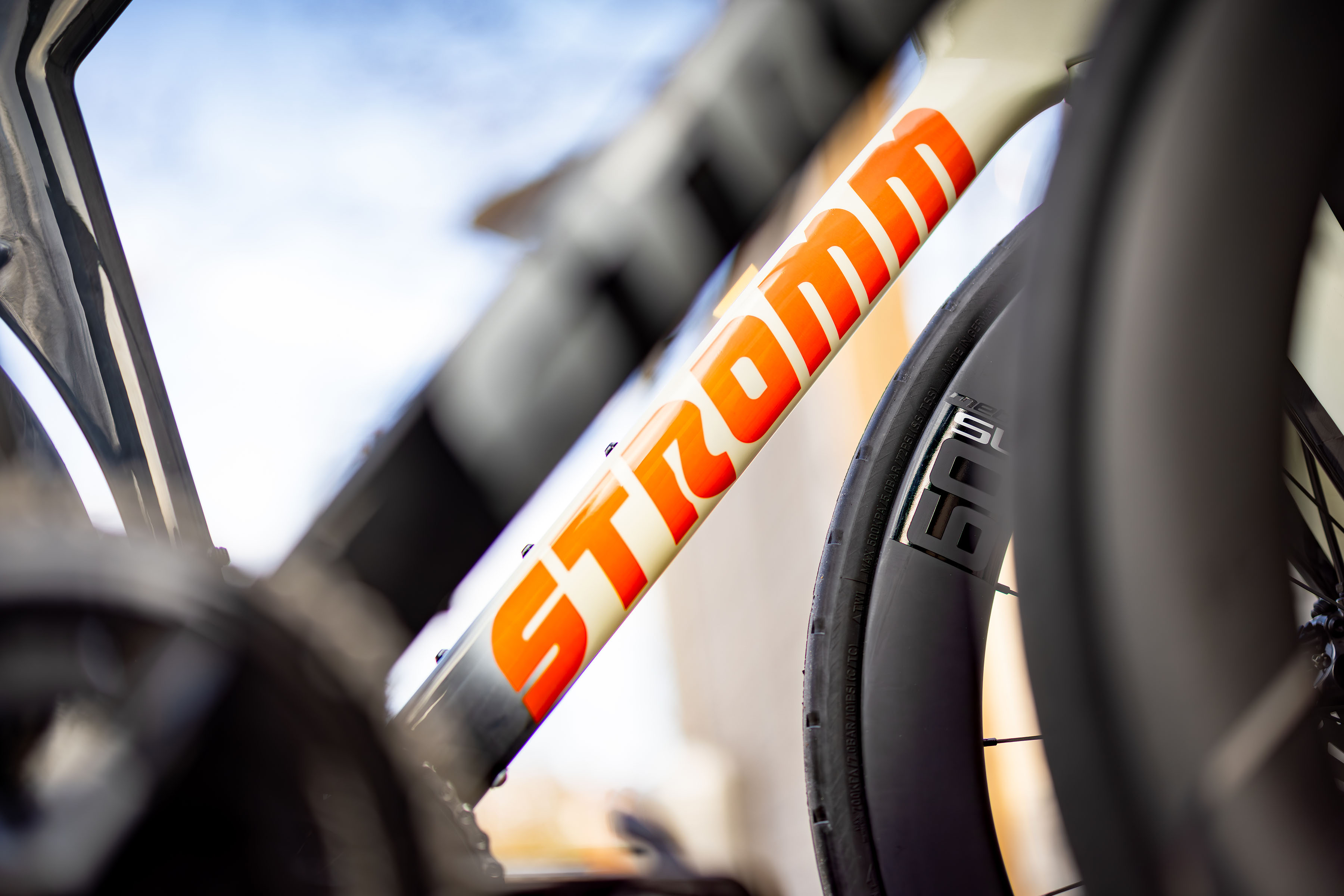 A closeup of the bright orange Stromm logo on their road bike.